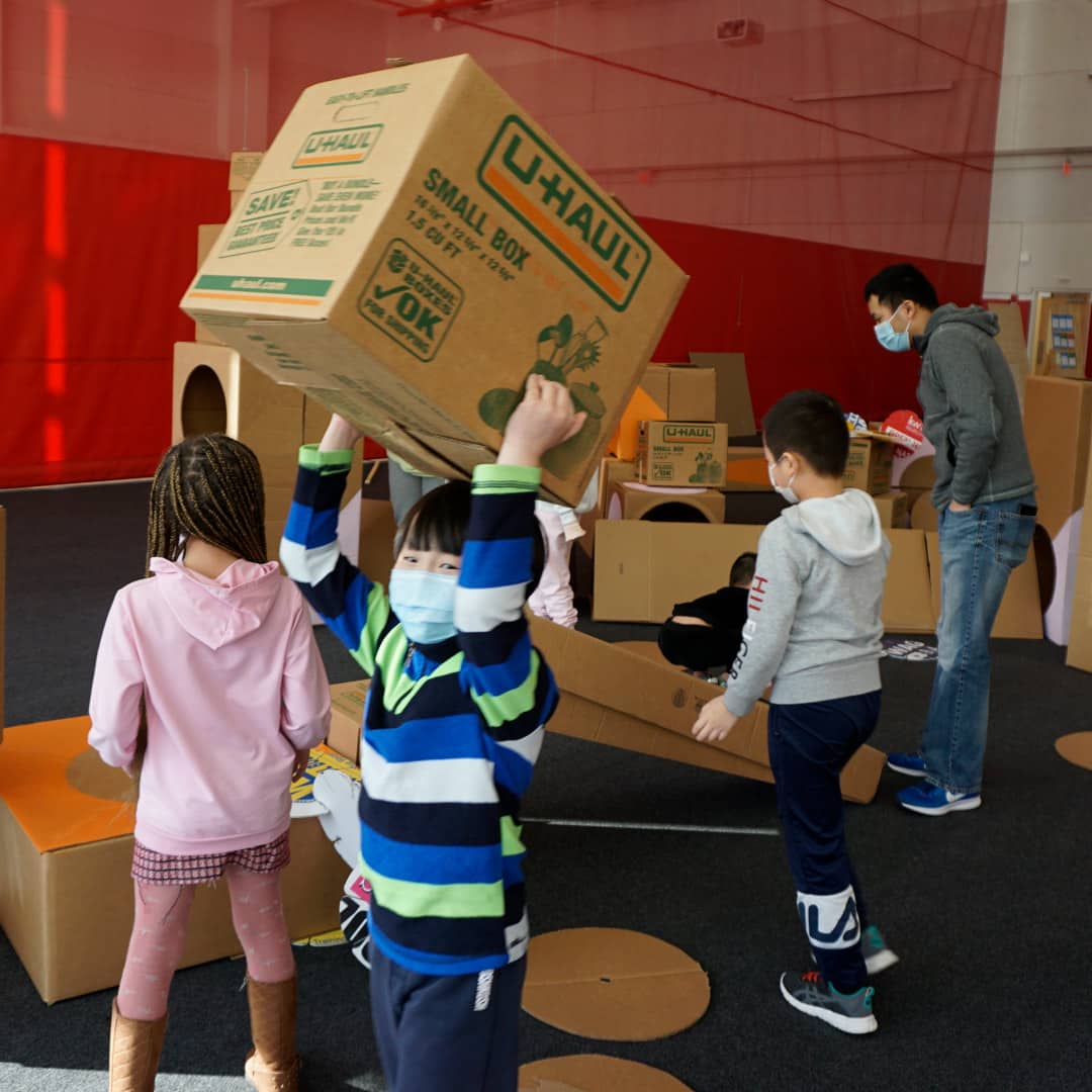 Kids use cardboard boxes for play at PCDC community engagement meeting