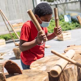 Boy drums with wood pieces